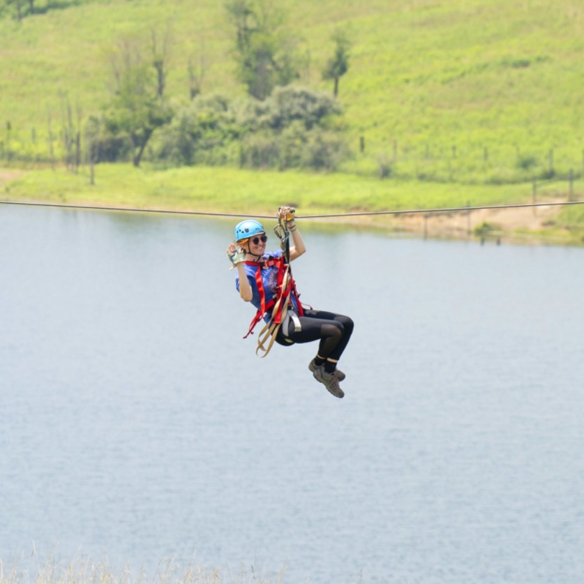 woman ziplining over water at The Wilds